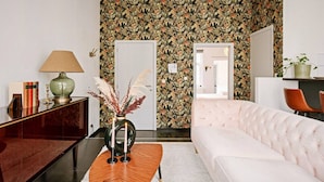 Een moderne woonkamer met een witte bank, een houten salontafel, een lamp en een decoratieve vaas.