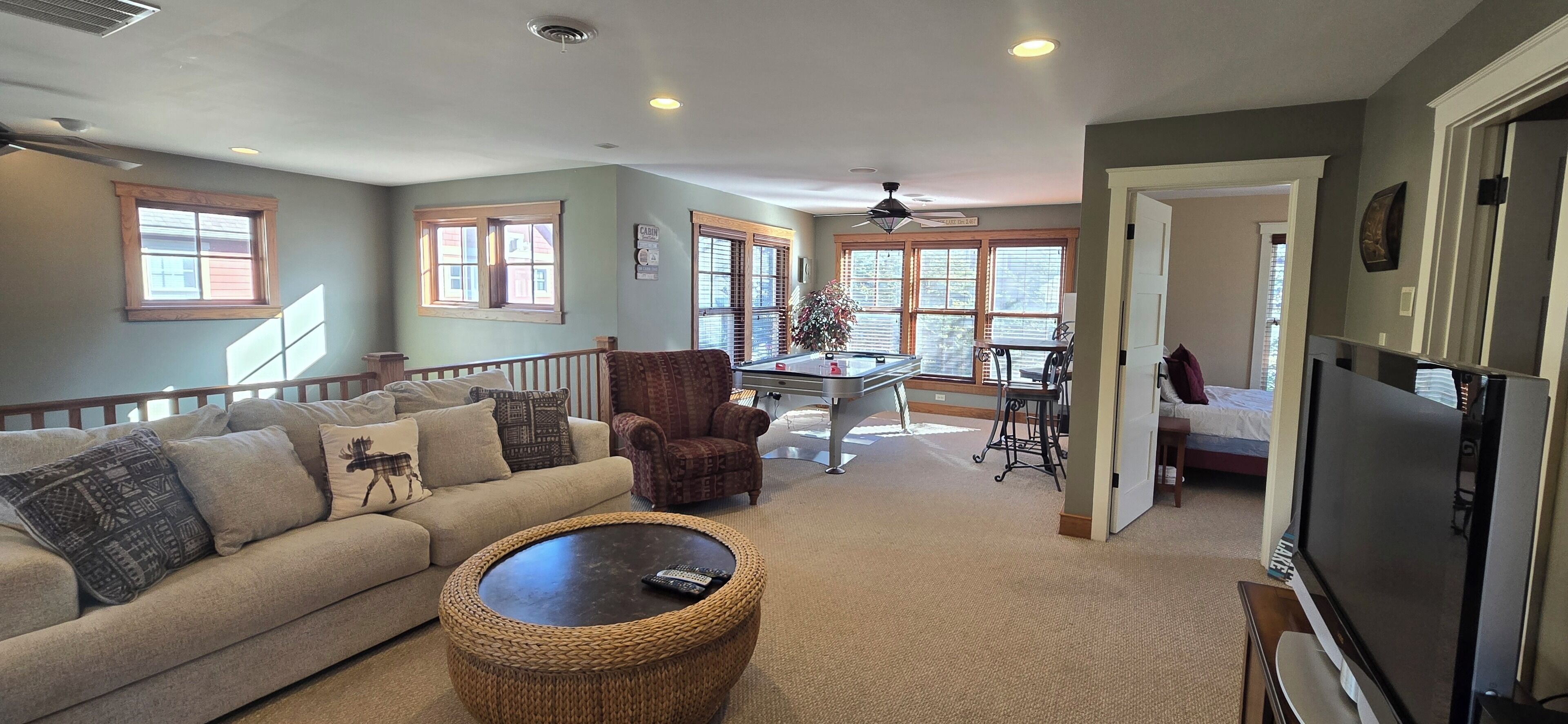 A spacious living room with a sofa, coffee table, and a dining area with a table and chairs.