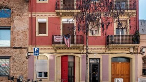 A multi-story building with balconies, a red door, and a sign for "Podlengo Republica Centro". - Ramon Turró - Nice apartment in Poble Nou near the beach (Barcelona)