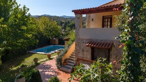 A two-story house with a swimming pool, surrounded by lush greenery and hills in the background. - Skine Dream Villa, Charming Villa with Private Pool (Platanias)
