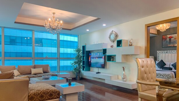Una sala de estar moderna con sofá, mesa de centro, televisor y objetos decorativos.