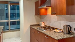 Una cocina moderna con armarios de madera, estufa a gas, hervidor y tostadora.