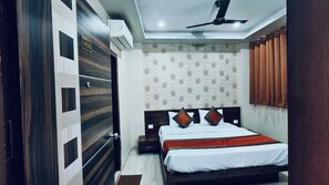 Ein Schlafzimmer mit Bett, Deckenventilator, Wandklimaanlage und strukturierter Tapete.
