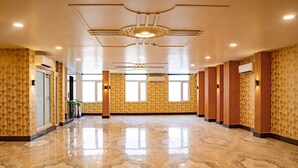 Un hall d’hôtel spacieux, doté d’un sol en marbre poli, de grandes fenêtres et d’un design moderne au niveau du plafond.