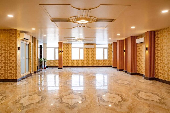 A spacious hotel lobby with a polished marble floor, large windows, and a modern ceiling design. - The Quade Villa By Spandan Holiday Homes (Varanasi)