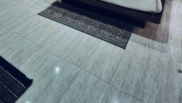 Une chambre d’hôtel moderne avec un grand lit, un ventilateur de plafond et une vue sur l’extérieur.