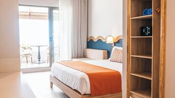 Habitación de hotel con cama, armario, ventilador de techo y vistas al exterior.