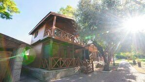 A wooden house with a balcony, surrounded by trees and a paved path. - Welt bungslows  (Konyaalti)
