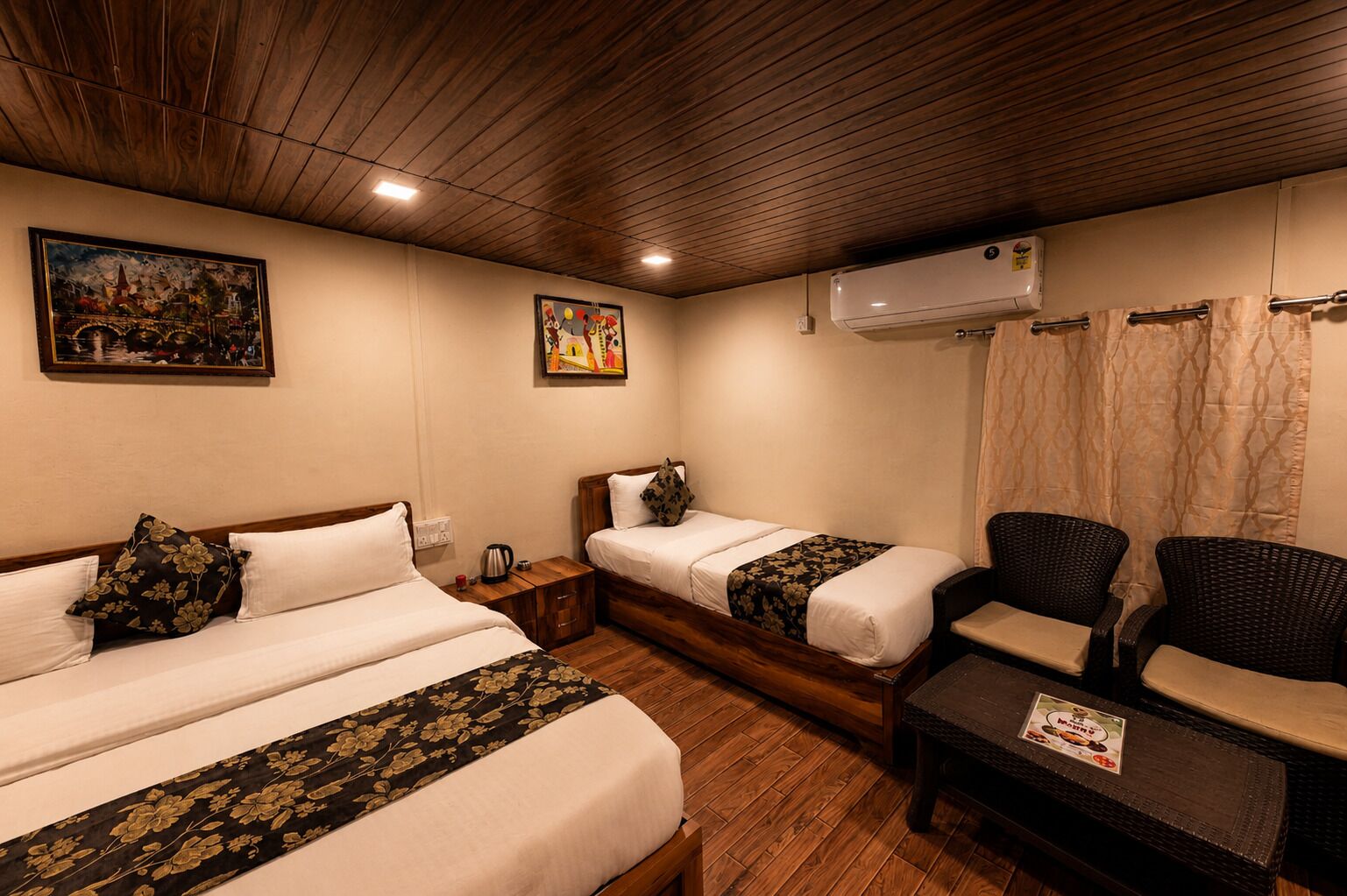 Habitación con dos camas, techo de madera, aire acondicionado, un cuadro y una silla.