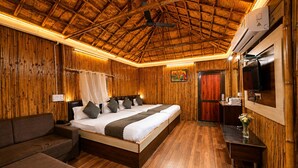 A room with a bed, a sofa, a TV, and a wooden ceiling. - Hotel Happy Forest - Boutique Garden Retreat in Mount Abu (Mount Abu)