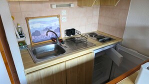 Eine Küche mit Spüle, Herd und Holzschränken.