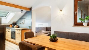 A modern kitchen with a dining area, a built-in oven, and a skylight. - Apartment "Rachel" with Mountain View, Shared Terrace and Wi-Fi (Perlesreut)