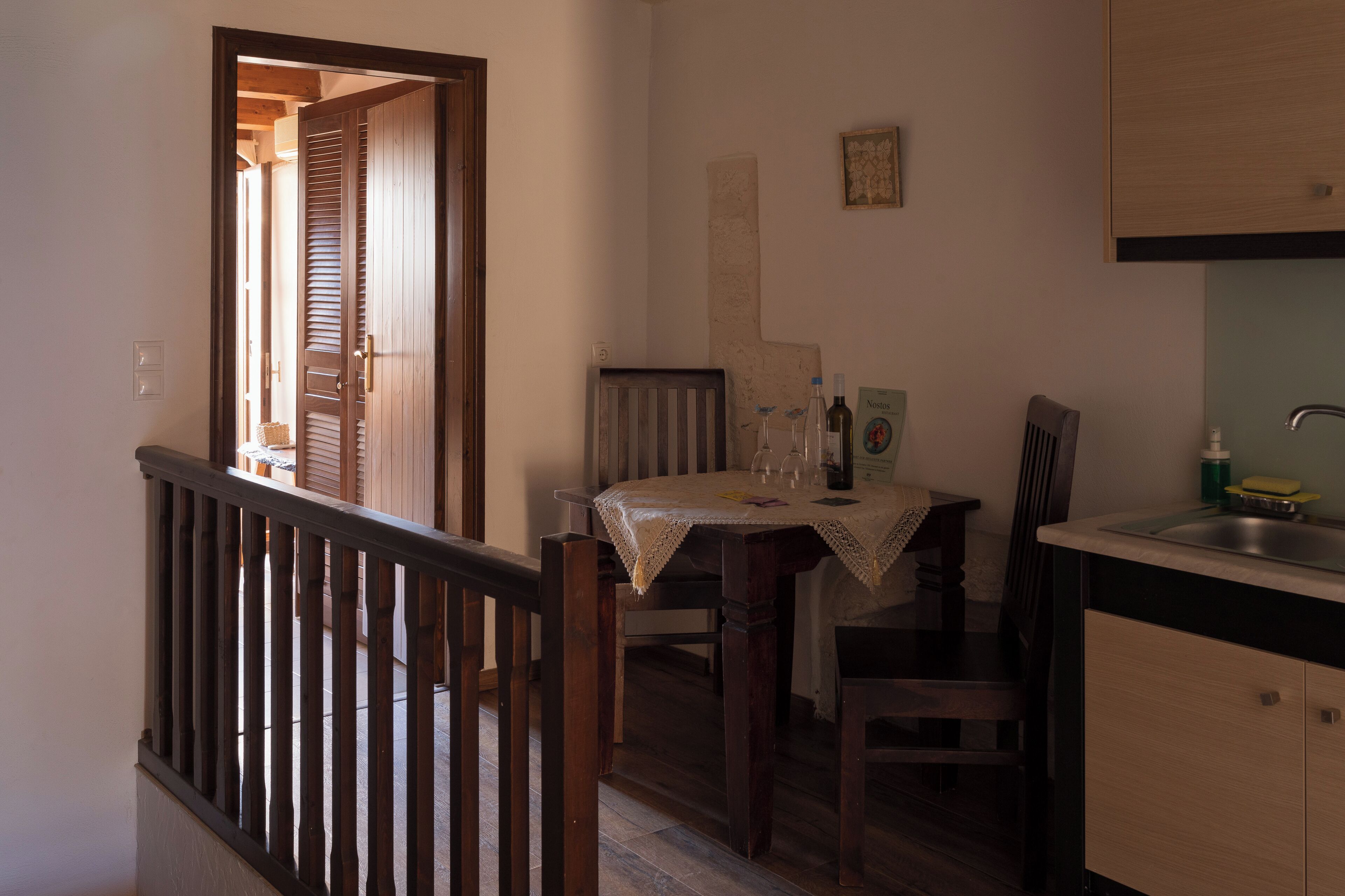 Un comedor con mesa, sillas y una encimera de cocina.