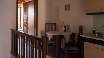 Un comedor con mesa, sillas y una encimera de cocina.
