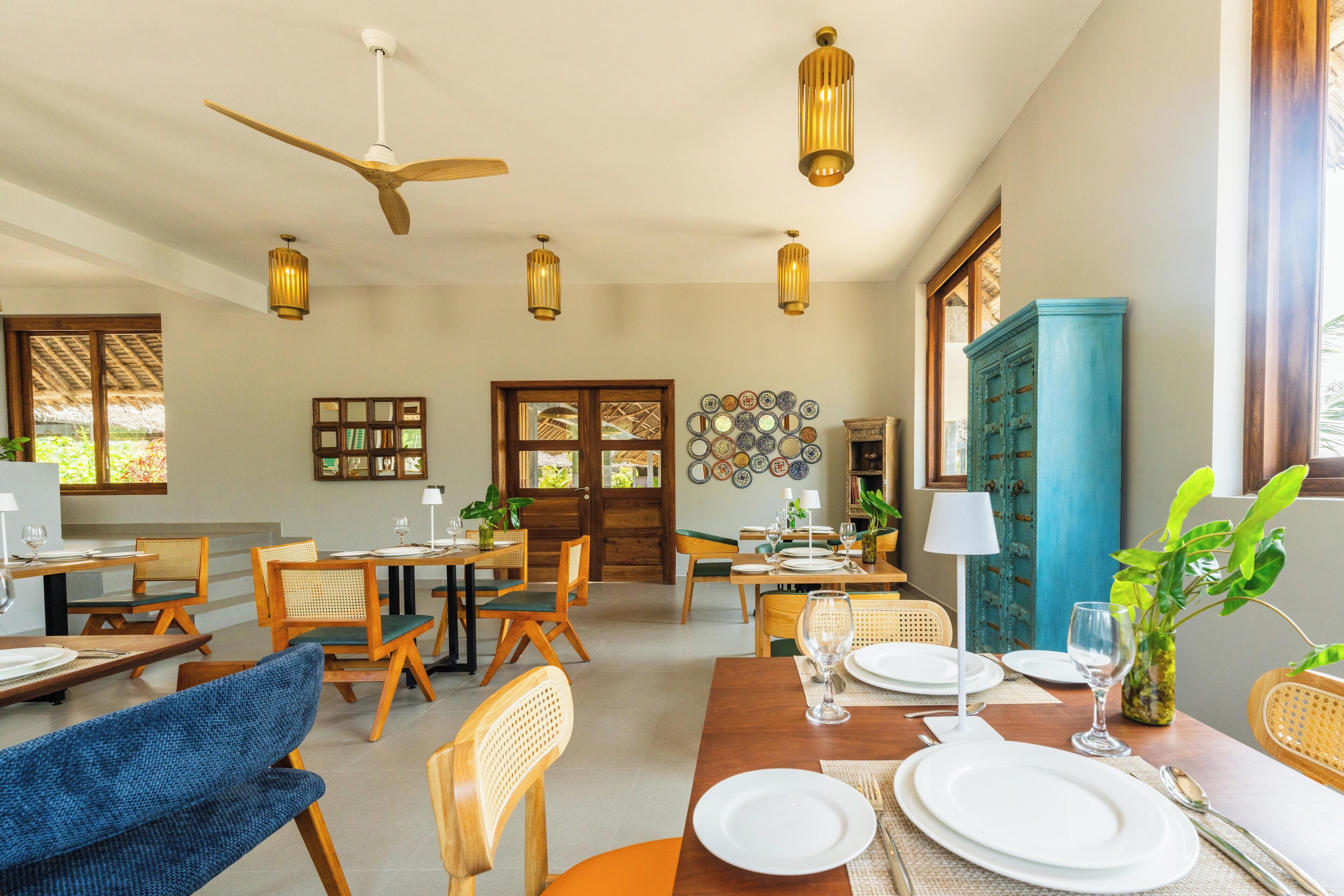 A dining area with wooden furniture, a ceiling fan, and pendant lights.