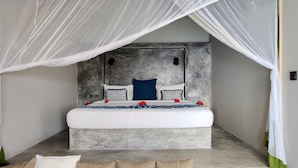 A bed with a grey headboard, white bedding, and red flowers. - Legendary Zanzibar Beach Resort (Michamvi)