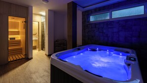 A modern bathroom with a hot tub, wooden paneling, a glass shower enclosure, and a stone wall with windows. - Luxury 4-bedroom Villa with Private Heated Pool & Sea View, near Portonovi. (Đenovići)
