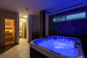 A modern bathroom with a hot tub, wooden paneling, a glass shower enclosure, and a stone wall with windows. - Luxury 4-bedroom Villa with Private Heated Pool & Sea View, near Portonovi. (Đenovići)