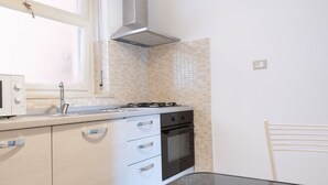 Una cocina moderna con armarios blancos, una estufa y un microondas.