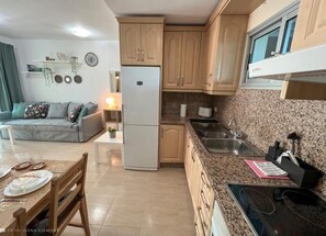 Uma cozinha moderna com bancadas de granito, forno embutido e frigorífico.