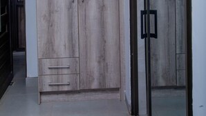 Una habitación moderna con un armario grande, un vidrio y piso de baldosas.