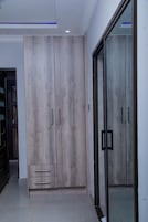 Una habitación moderna con un armario grande, un vidrio y piso de baldosas.