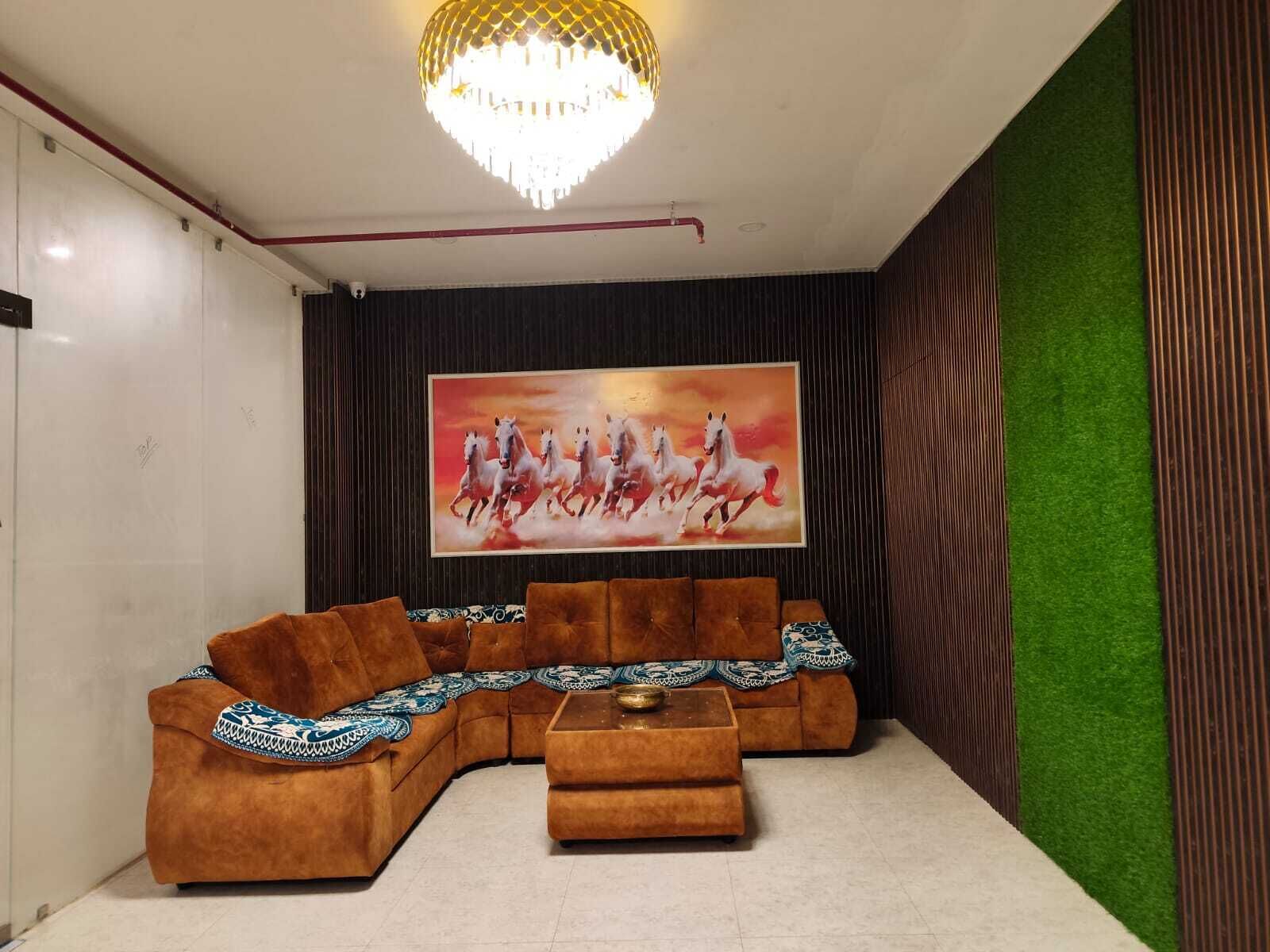A living room with a sectional sofa, a coffee table, a chandelier, and a painting of horses.