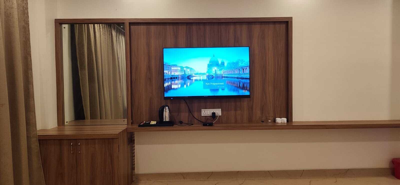 Televisor fixat a una paret de fusta amb vista a un paisatge urbà.