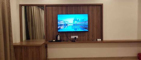 Televisor fixat a una paret de fusta amb vista a un paisatge urbà.