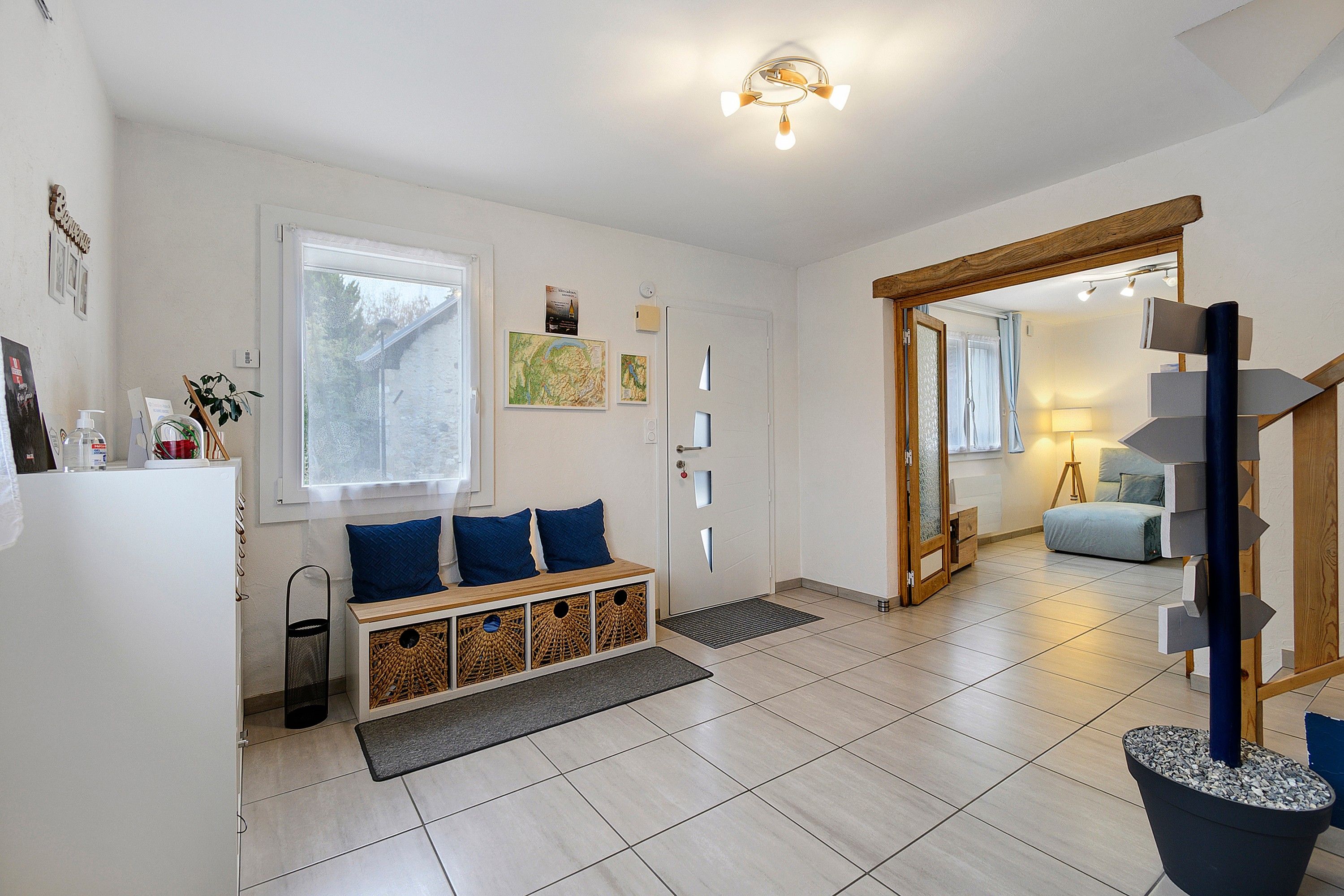 Una sala moderna con un banco integrado, una escalera y vistas al dormitorio contiguo.
