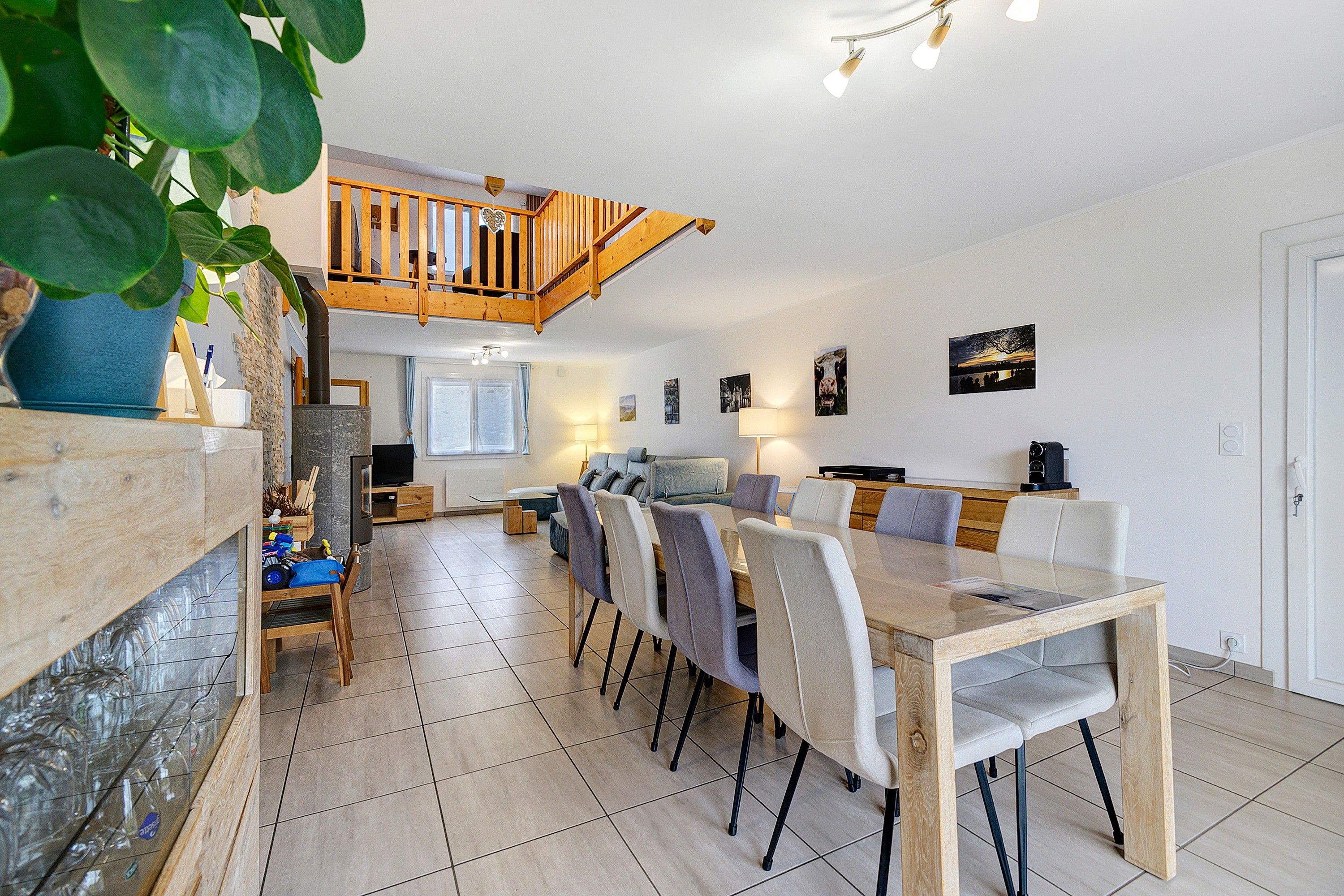 A spacious dining area with a high wooden ceiling and a view of the kitchen below.