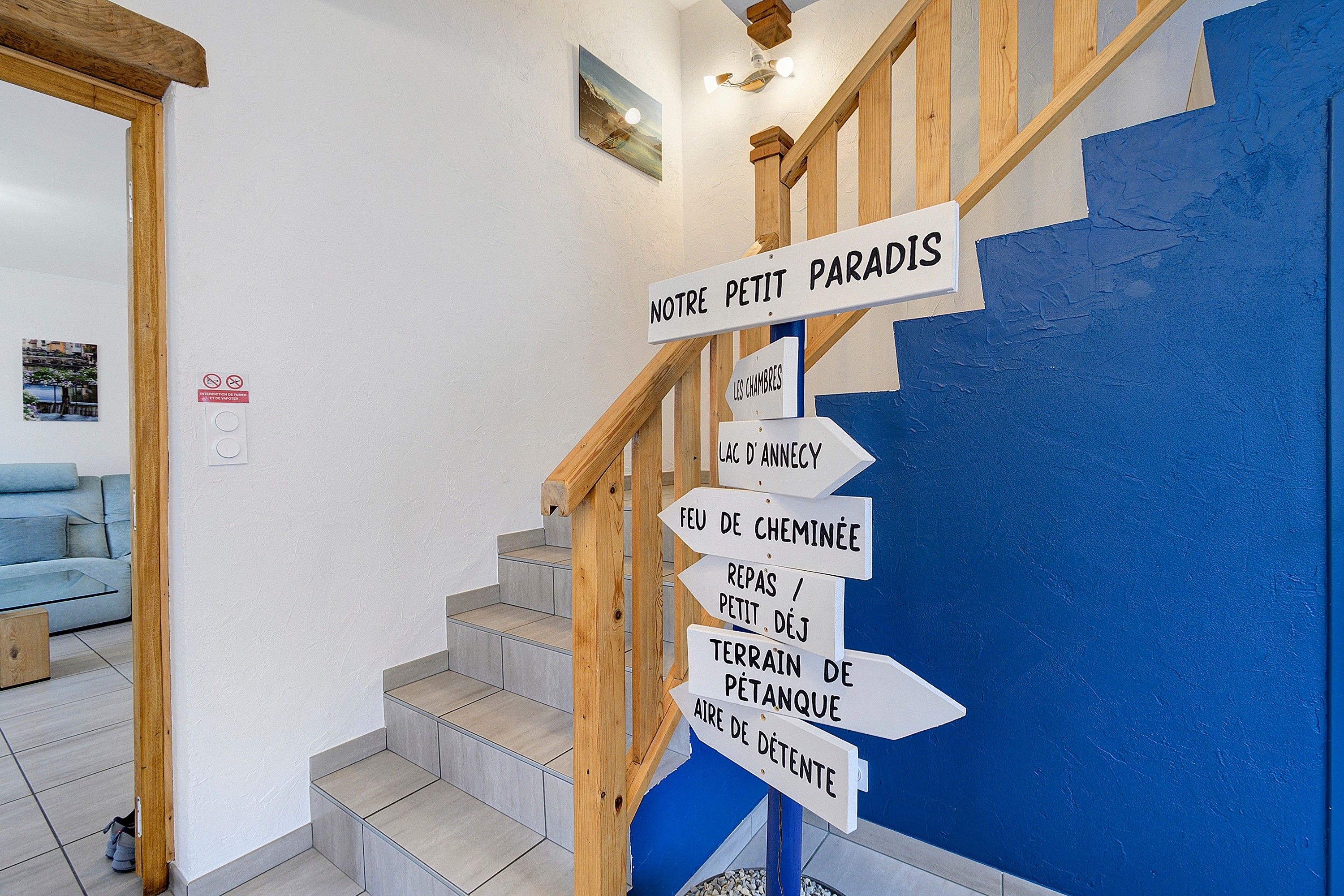 Una escalera con barandillas de madera y una pared azul.