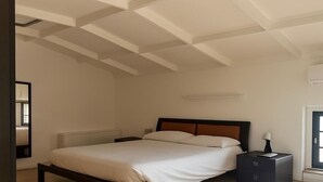 A modern bedroom with a bed, bedside tables, and a nightstand. - La Manovella Apartment (Caselle Torinese)