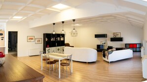 A spacious living area with a dining table, chairs, a sofa, and a TV. - La Manovella Apartment (Caselle Torinese)