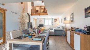 A modern kitchen with a dining area, wooden accents, and a staircase. - Guest Room "Room 2 - Seychelles" with Shared Terrace, Garden, and Wi-Fi (Annecy)