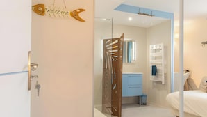 A modern bedroom with a bed, a bedside table, a nightstand, a wardrobe, and a bathroom with a shower and a mirror. - Guest Room "Room 2 - Seychelles" with Shared Terrace, Garden, and Wi-Fi (Annecy)