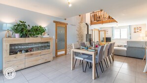 A modern living room with a dining area, wooden furniture, a staircase, and a kitchen visible in the background. - Guest Room "Room 2 - Seychelles" with Shared Terrace, Garden, and Wi-Fi (Annecy)