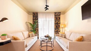 A living room with two sofas, a coffee table, and a TV mounted on the wall. - Wonderful 5-bedroom Apart in Granada. Recogidas II (Granada)