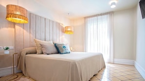 A bedroom with a bed, two pendant lights, a bedside table with a plant, and a large window with curtains. - Wonderful 5-bedroom Apart in Granada. Recogidas II (Granada)