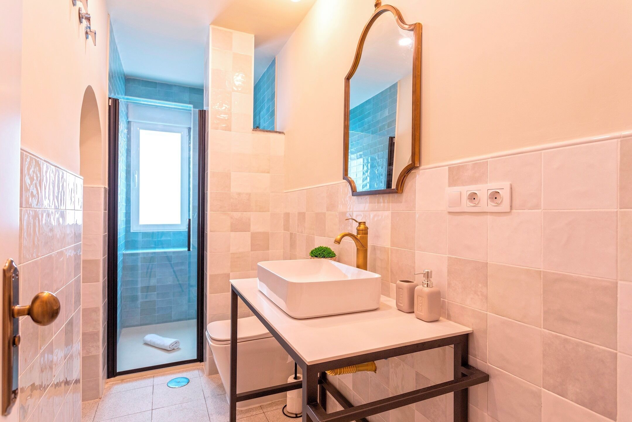 A modern bathroom with a glass shower enclosure, a white sink, and a large mirror.