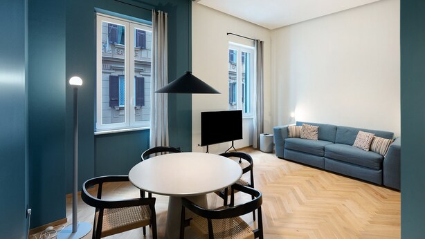 A modern living room with a dining area, a sofa, and a TV. - Superior Family Apartment with Wi-Fi and Air Conditioning (Napoli)