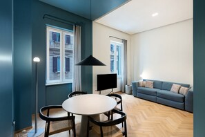Un salon moderne comprenant un coin repas, un canapé et un téléviseur.