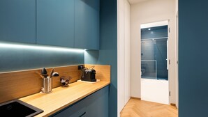 A modern kitchen with a wooden countertop, a black sink, and a coffee machine. - Superior Family Apartment with Wi-Fi and Air Conditioning (Napoli)