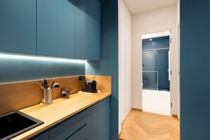 A modern kitchen with a wooden countertop, a black sink, and a coffee machine. - Superior Family Apartment with Wi-Fi and Air Conditioning (Napoli)