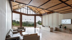 A spacious lobby with a high ceiling, large windows, and a reception desk.