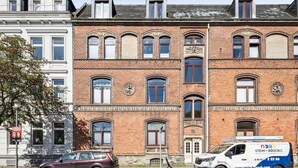 Een historisch gebouw met veel ramen en een bakstenen gevel.