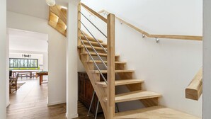 A wooden staircase with metal railings leading to an upper floor.