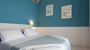 A hotel room with a bed, a nightstand, and two wall-mounted paintings. - Hotel New Castle (Cesenatico)