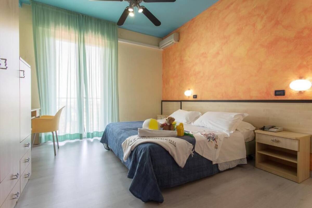 A bedroom with a bed, bedside table, and a chair.