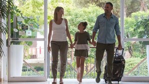 A family walking through a glass door with a view of greenery outside. - Hotel New Castle (Cesenatico)
